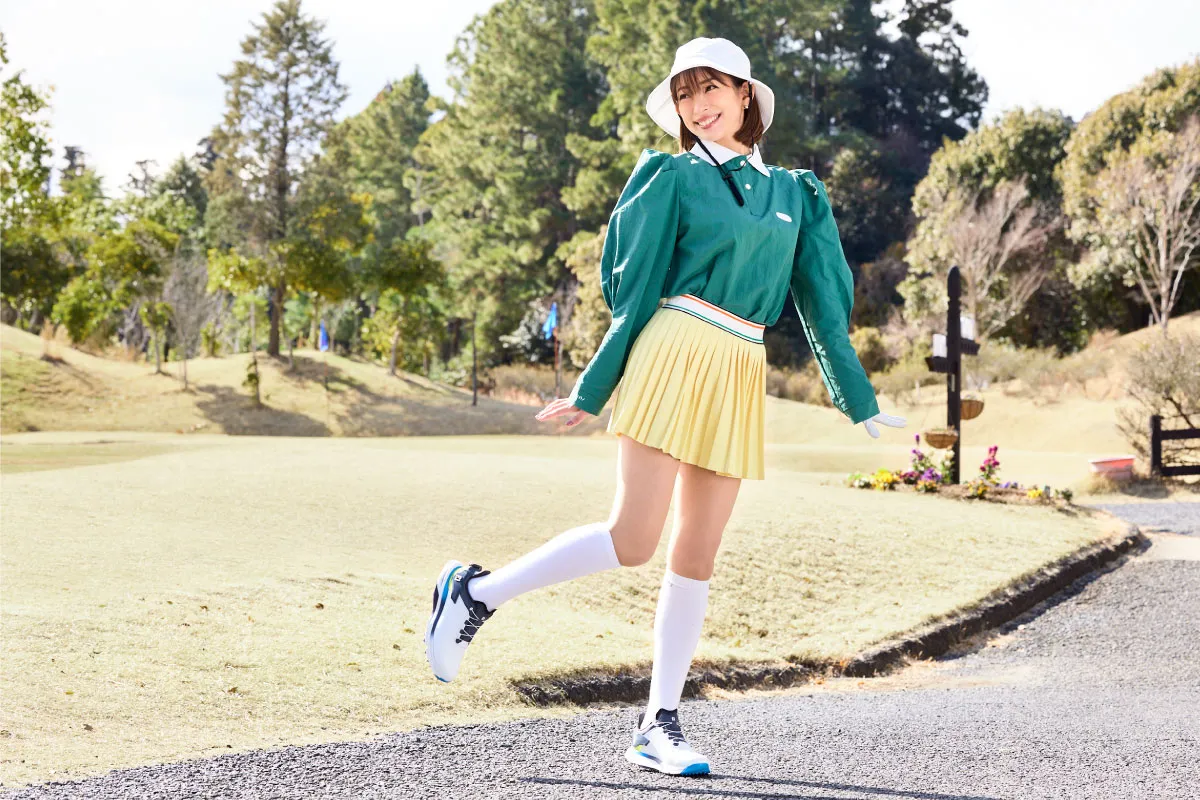 Woman golfer in a green top and light hat